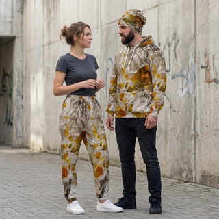 ERDGEWEBE Unisex-Trainingshose von REBL ART, Frau und Mann ganz vor der Graffitiwand